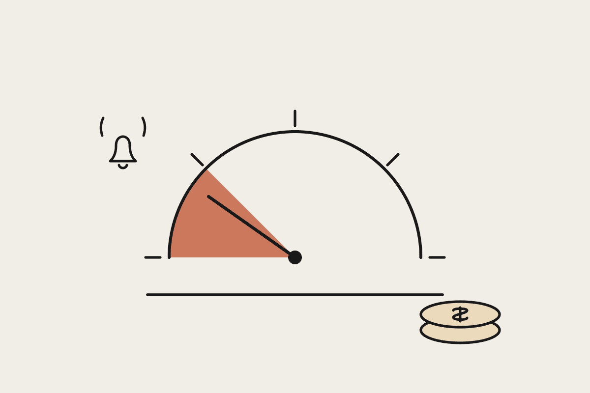 Hand-drawn spend gauge with the needle resting in a terracotta safe zone, beside a small stack of coins and a ringing alert bell